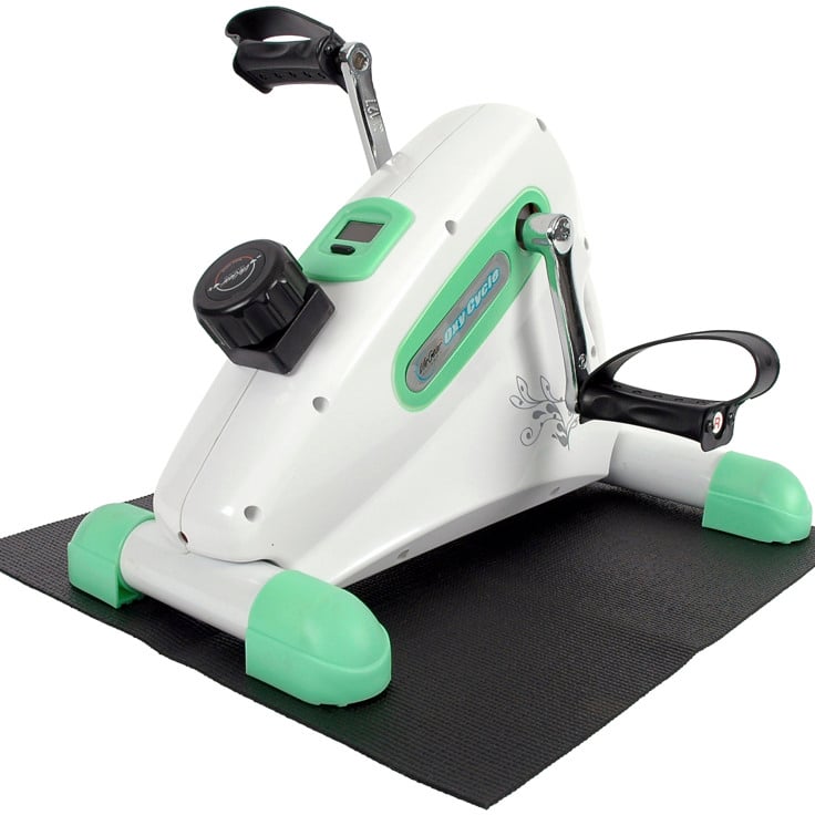 En vit och grön motionscykel på en svart matta.