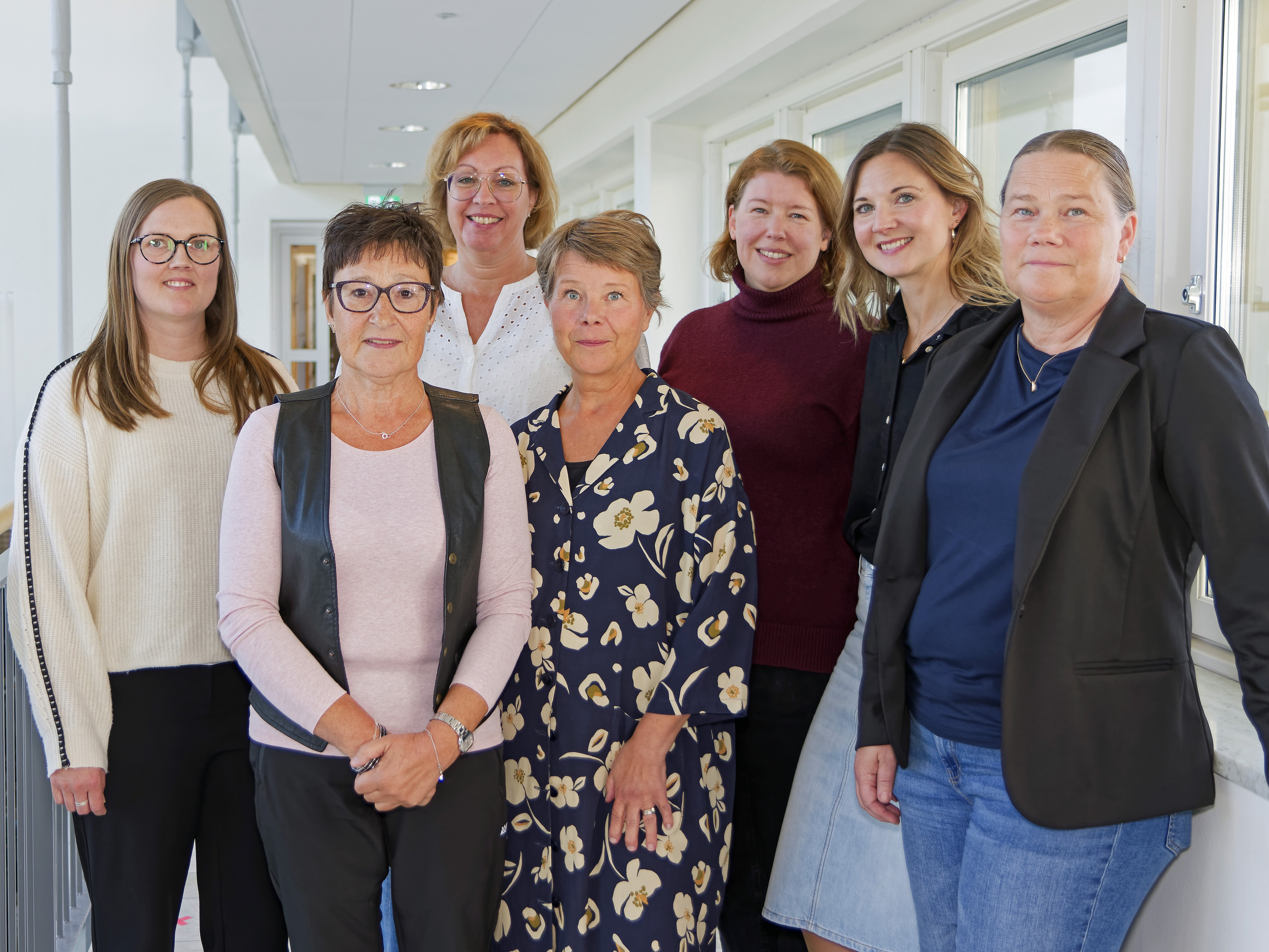 En grupp kvinnor som står bredvid varandra i en korridor.