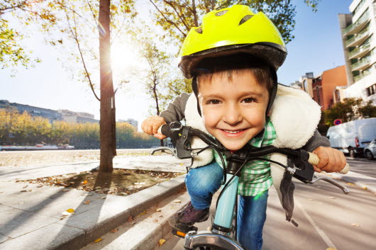 Pojke i gul cykelhjälm cyklande i full fart