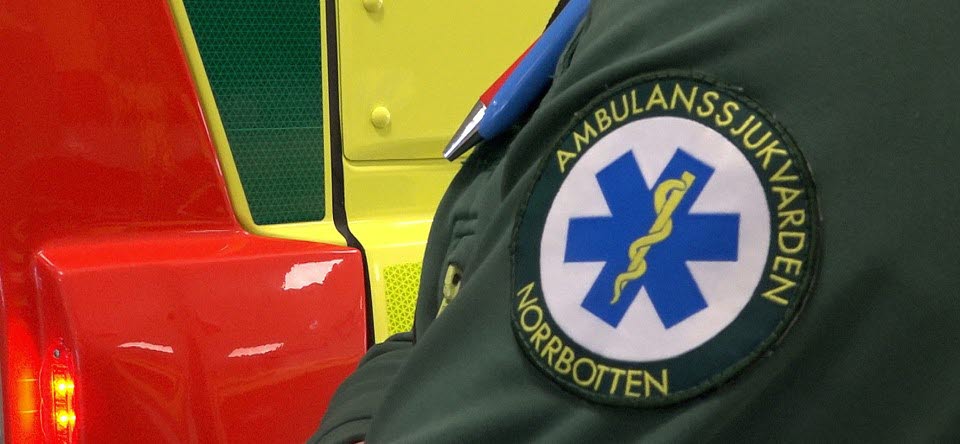 närbild på del av ambulans och en arm med logga för ambulanssjukvården i Norrbotten